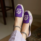 Purple floral Ladies Khussa shoes worn by a female model with a blurred background