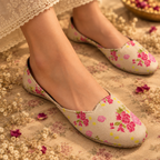 A girl wearing beige flat shoes with a pink and green floral handmade printed ladies khussa