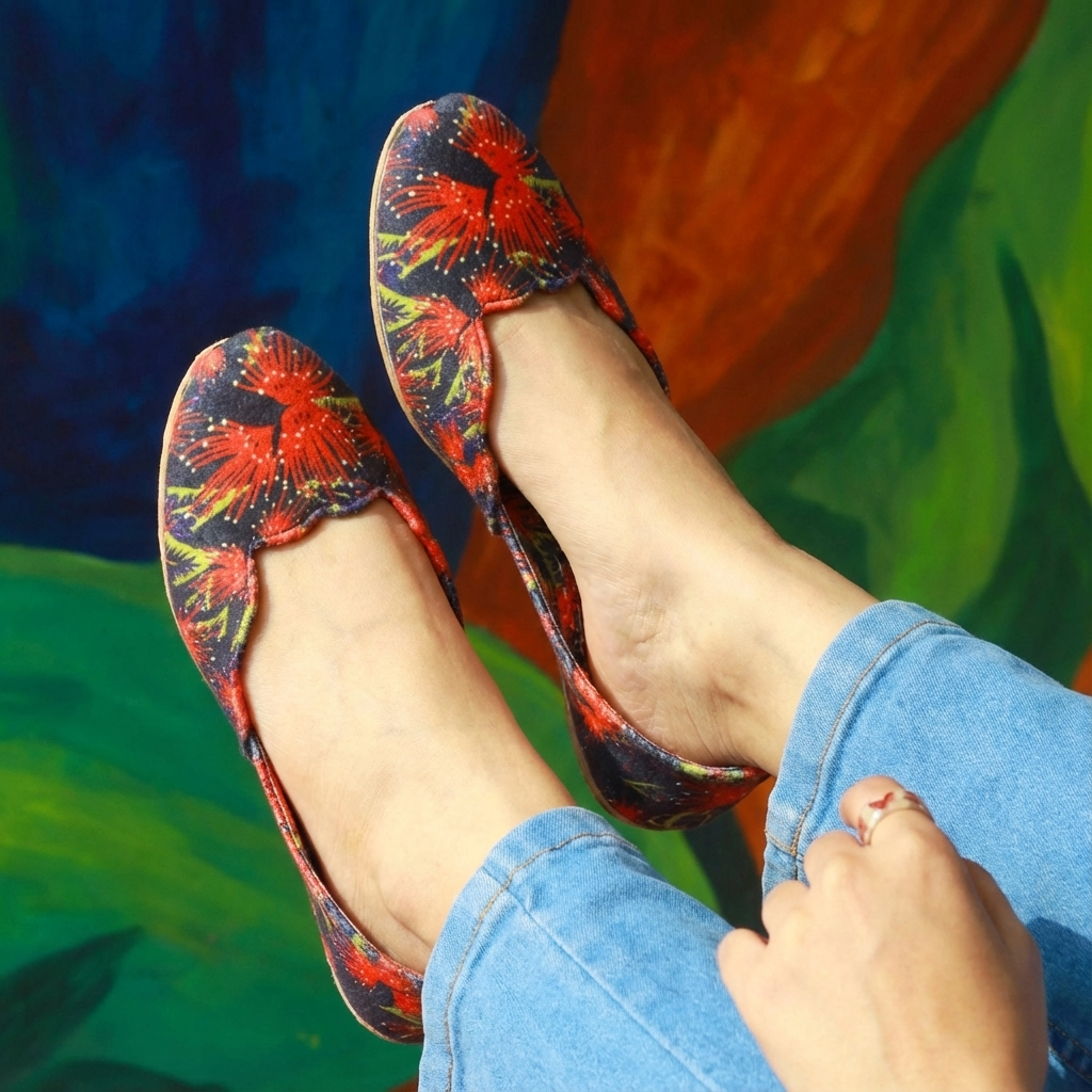 Colorful floral-patterned ladies khussa shoes worn with blue jeans against a colorful background