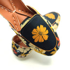 Floral-patterned khussa with a yellow flower design on a black background