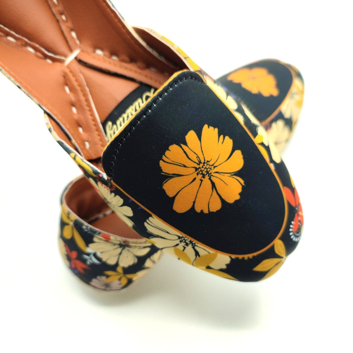 Floral-patterned khussa with a yellow flower design on a black background